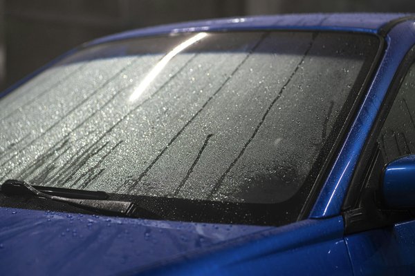 How can you effectively use water-repelling treatments on UK car windows and mirrors?